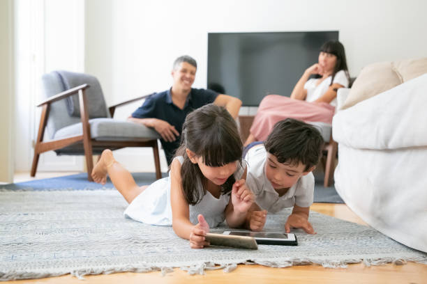 istock Happy parent watching little kids lying on floor 1267089372