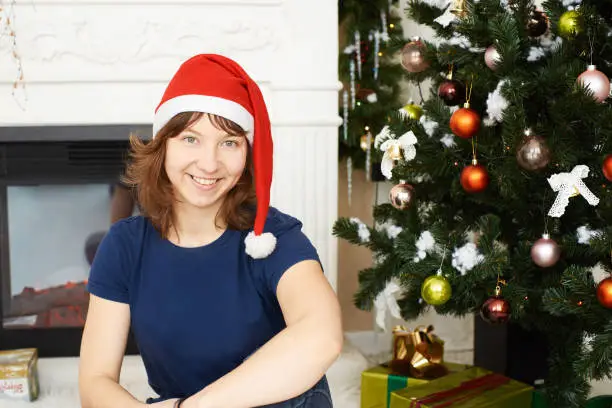 Young girl sitting xmas tree