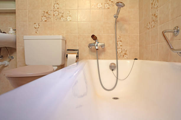 istock Old bathroom, brown tiled interior with bathtub, assistive handle 1267092492