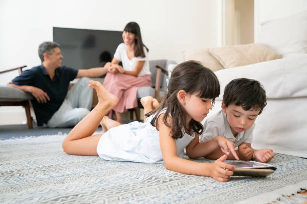 istock Happy parents watching cute children lying on floor 1267092719