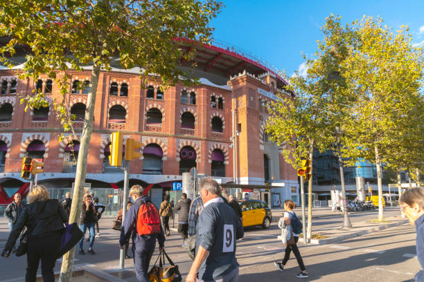 바르셀로나 도심의 유리 엘리베이터와 옥상 테라스가 있는 랜드마크 쇼핑몰인 아레나스 데 바르셀로나(arenas de barcelona)를 가로지르는 보행자. - clear sky glass façade built structure fountain 뉴스 사진 이미지