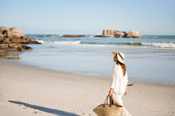 istock Beautiful woman in white walking on the beach 1267096013