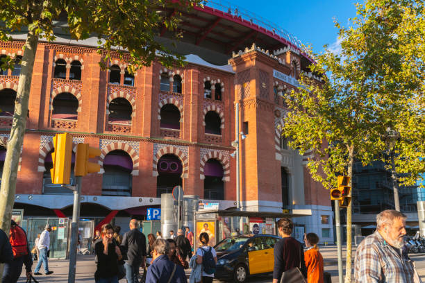 바르셀로나 도심의 유리 엘리베이터와 옥상 테라스가 있는 랜드마크 쇼핑몰인 아레나스 데 바르셀로나(arenas de barcelona)를 가로지르는 보행자. - clear sky glass façade built structure fountain 뉴스 사진 이미지