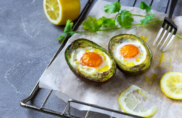 istock Keto diet dish: Baked avocado Boats with eggs and lemon on grey background 1267098350