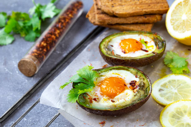 istock Keto diet dish: Baked avocado Boats with eggs and lemon on grey background 1267098361