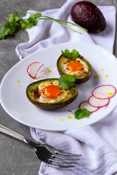 istock Baked eggs in avocado Boats with radish on white plate 1267098880