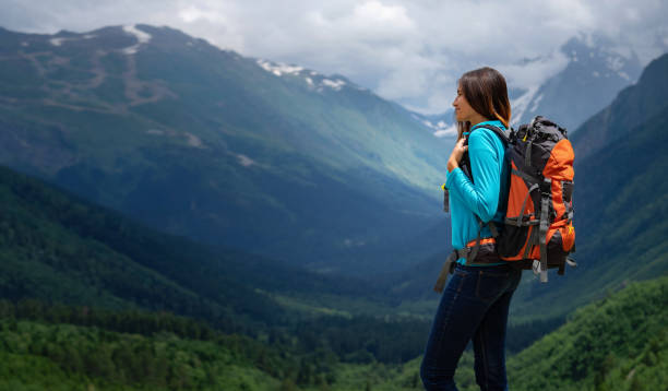 istock Backpacker on top of a mountain enjoying valley view 1267099166