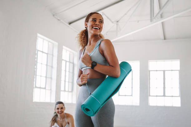 donna fitness a una lezione di yoga - friendship women exercising gym foto e immagini stock