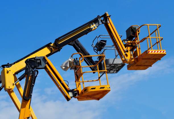istock Yellow and black aerial platform baskets against blue sky. 1267099181