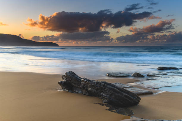 istock Sunrise by the sea with rocks., clouds and beach 1267099583