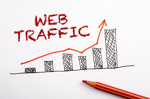 WEB TRAFFIC concept. Statistics graph with arrow. Red pencil on a white sheet of paper
