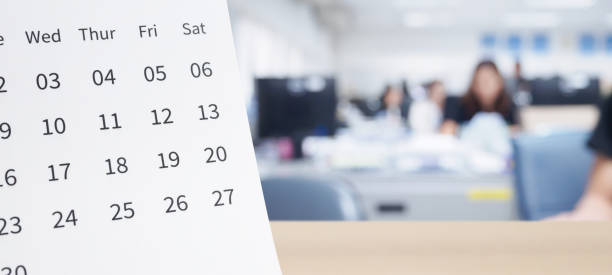 istock White paper desk calendar on wood table top with blurred office interior background 1267101653
