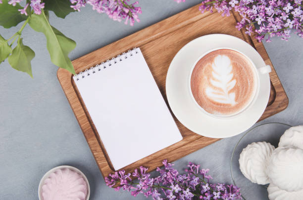 istock Lilac, coffee cup with latte art and marshmallow on white wooden table. Flat lay 1267101655