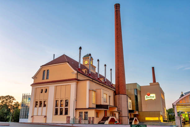 Pilsner Urquell Brewery Pilsen, Czech Republic - August 8, 2020: View of the historic Pilsner Urquell brewery building. The company logo is clearly visible on one of the walls. The picture was taken at sunset. Pilsen is famous for being the birthplace of the Pilsner beer style. pilsen stock pictures, royalty-free photos & images