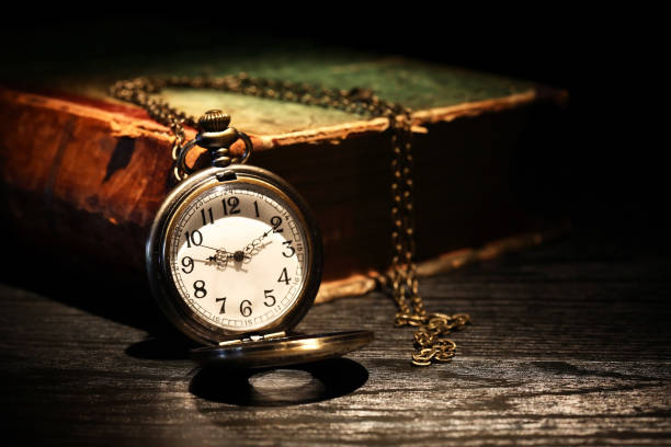 istock Old Watch Near Book 1267103301