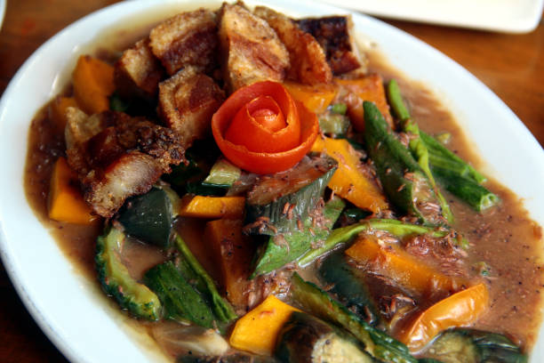 Filipino dish called Pinakbet or mixed vegetables in fish paste sauce with crispy pork belly stock photo