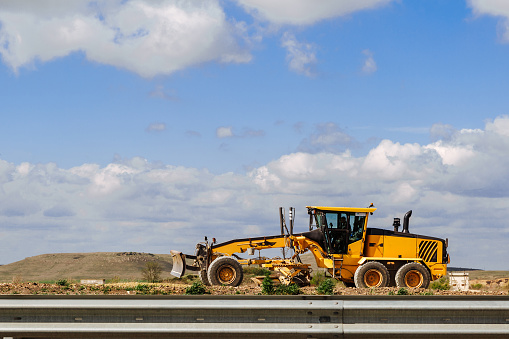 Grader yellow. Grader road construction, industrial machine for the construction of new roads.