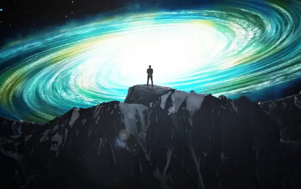 Silhouette of a man on a mountain against the background of a new galaxy