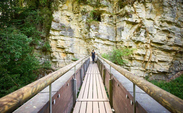 Woman, tourist enjoy the scenic view from hiking wooden trail at Bushkill Falls, Pocono Mountains in Pennsylvania