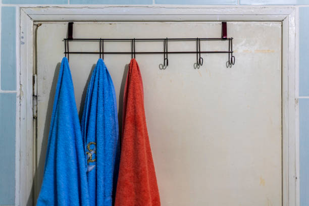 istock Hanging towels on a worn wooden bathroom door. Copy space for text. 1267109687