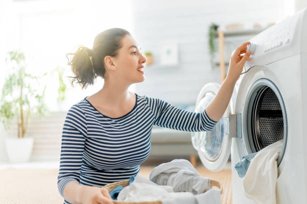 frau macht wäsche - waschmaschine stock-fotos und bilder