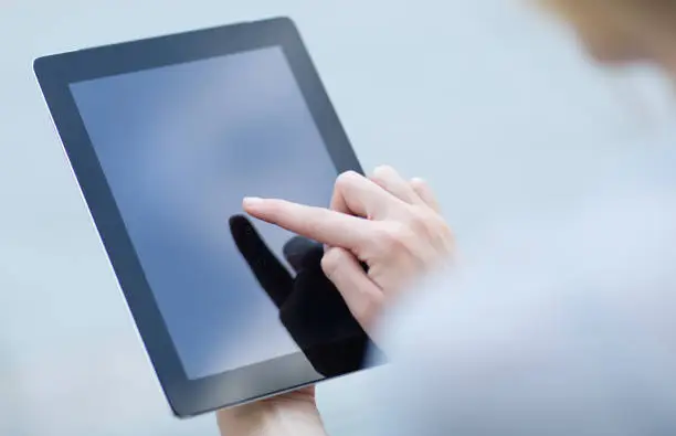 Photo of Woman using a digital touchscreen tablet. Online banking, business and shopping.