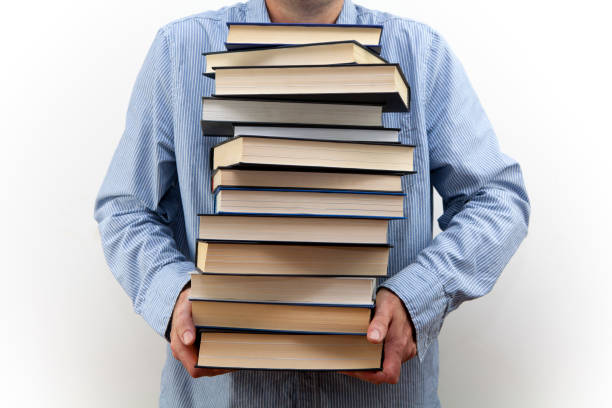 istock Man holding a pile of books 1267112250