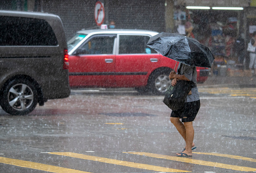 People walk on the street in rainy day on Hong Kong City .