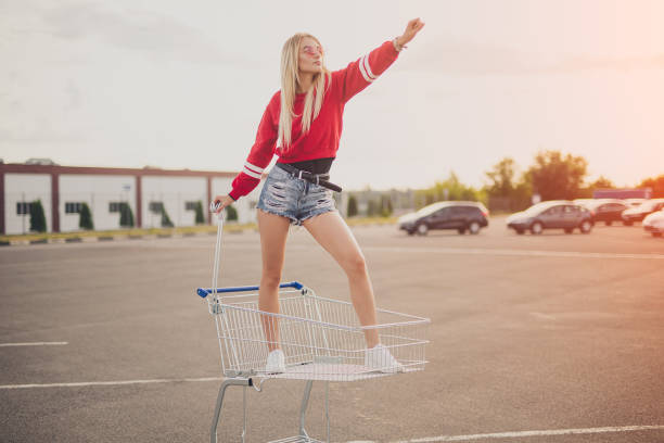 istock Confident young woman standing in shopping trolley 1267112706