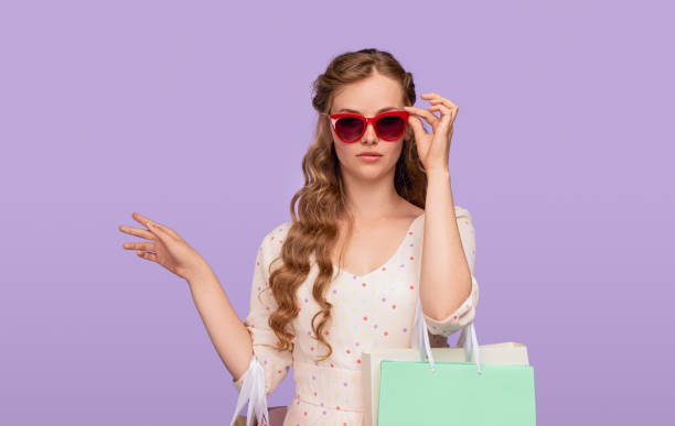 istock Stylish woman adjusting sunglasses during shopping 1267112773