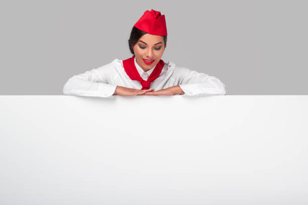 istock Smiling air hostess with blank white banner 1267112797