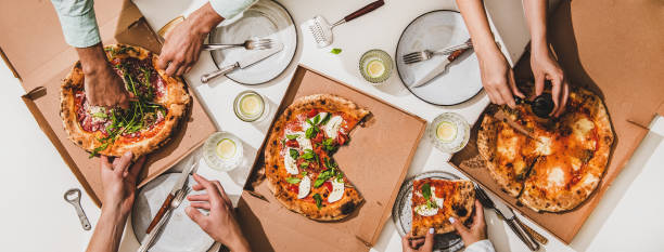 istock Flat-lay of various pizzas, lemon drinks and peoples hands 1267112846