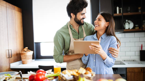 istock Copule in home kitchen looking at recipe on the web and cooking 1267113612