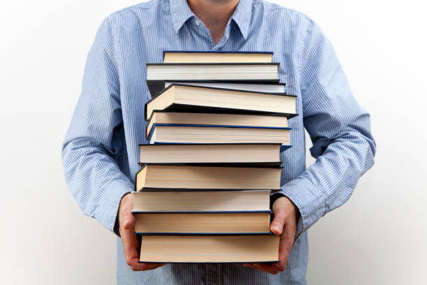 istock Man holding a pile of books 1267113638