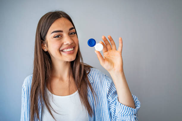 Happy Woman Holding Contact Lenses Case. Woman  holding container for transparent soft contact lens. Young woman is preparing to insert lens in her eyes. Ophthalmic diseases and treatment. Poor vision concept. contact lens photos stock pictures, royalty-free photos & images