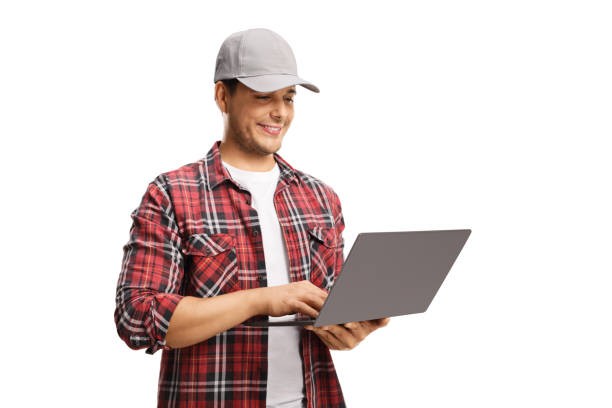 istock Young man with a cap and a checkered shirt working on a laptop computer 1267129919
