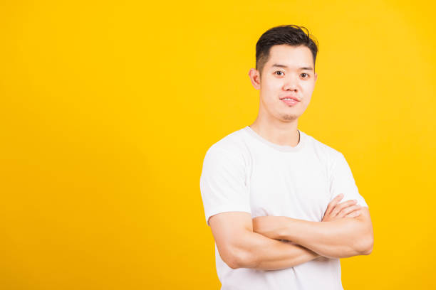 istock handsome young man smiling standing folded or crossed arm 1267131765