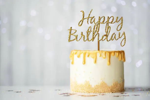 Golden birthday cake with happy birthday sign
