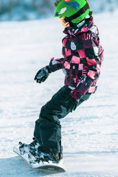 istock Cute Boy Snowboarding Down the Slope 1267134358