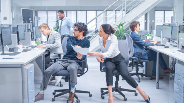 istock Diverse Team of Business Managers and Specialists Work on Desktop Computers with Two Rows of Tables Side by Side. Young and Motivated Business people in Modern Open Office. 1267134494