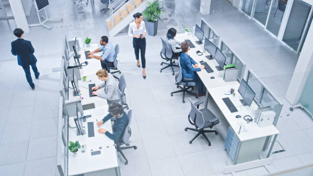 istock Diverse Multinational Team of Business Managers and Specialists Work on Desktop Computers, Have Discussion with Colleagues. Young and Motivated Business People in Modern Open Office. Shot from Above. 1267134511