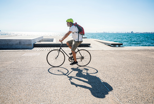 Man riding bicycle on the promenade along the seaside