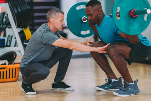 パーソナルトレーナー、ウエイトリフティングでのスポーツトレーニング - men weight training african descent male ストックフォトと画像
