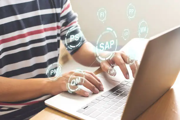 Photo of Close-up image of male hands working on laptop. Business management software (SAP). ERP enterprise resources planning system concept