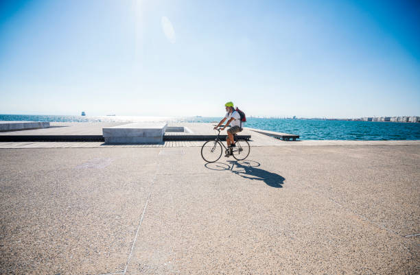 istock Man riding bicycle on the promenade along the seaside 1267136415