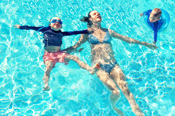 istock Mother and children in swimming pool 1267141348