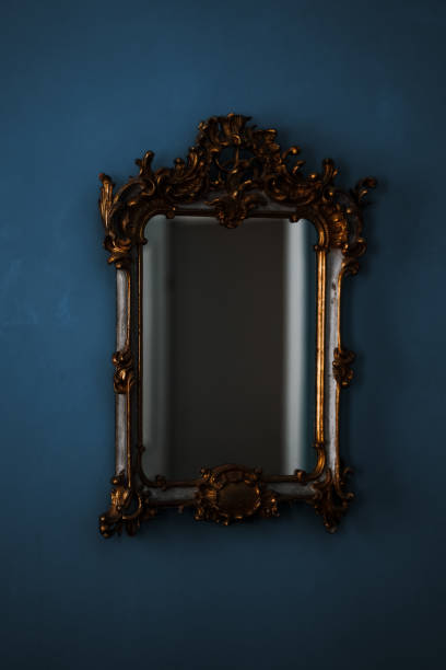 istock Close up of ancient mirror on blue wall. Beautiful large vintage mirror with decorative frame 1267141728