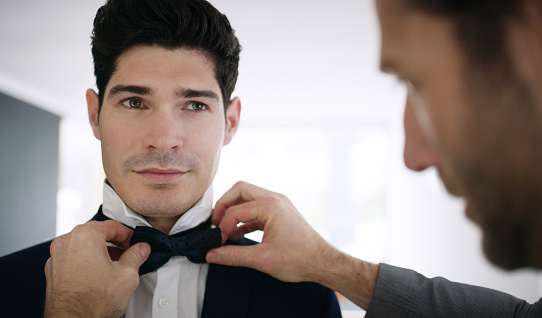 Shot of the groom and his best man getting ready in a room