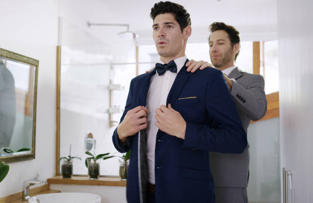 We definitely look our best Shot of the groom and his best man getting ready in a room dinner jacket stock pictures, royalty-free photos & images