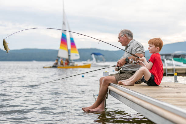 avô e neto pescando no verão - fishing lake grandfather grandson - fotografias e filmes do acervo